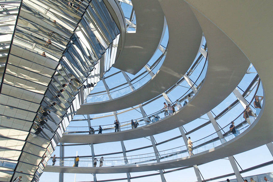 Blick in das Innere der Berliner Reichtstagskuppel mit der spiralförmigen Rampe, auf der Besucher flanieren - ein lohnendes Ziel für Ferien in Berlin